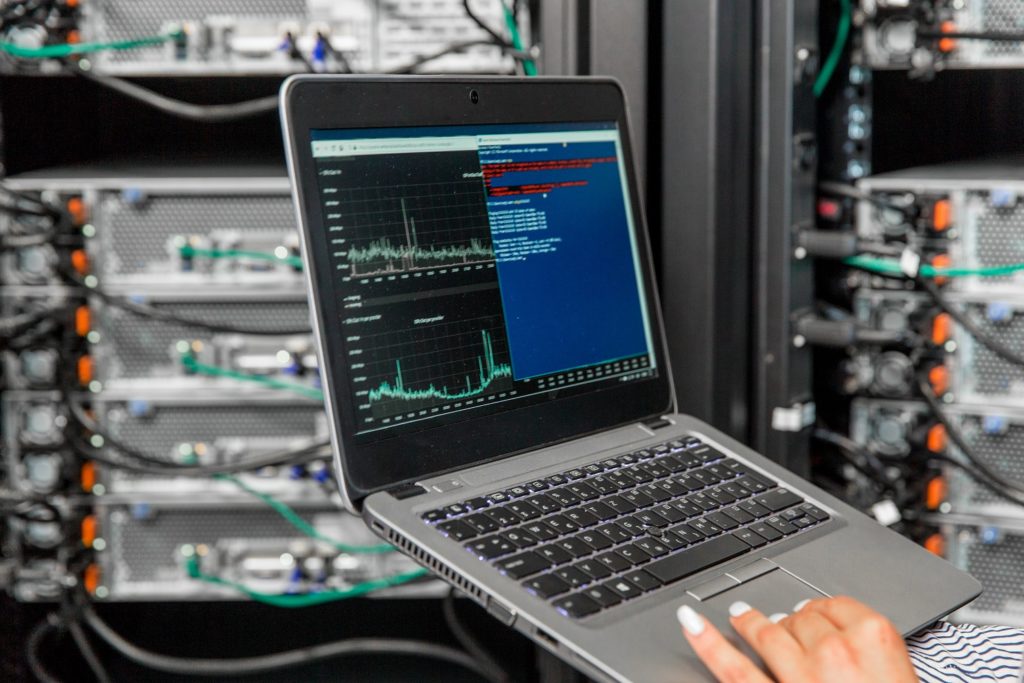 Female IT Engineer Using Laptopf for Analysis of Network Servers in Server Room